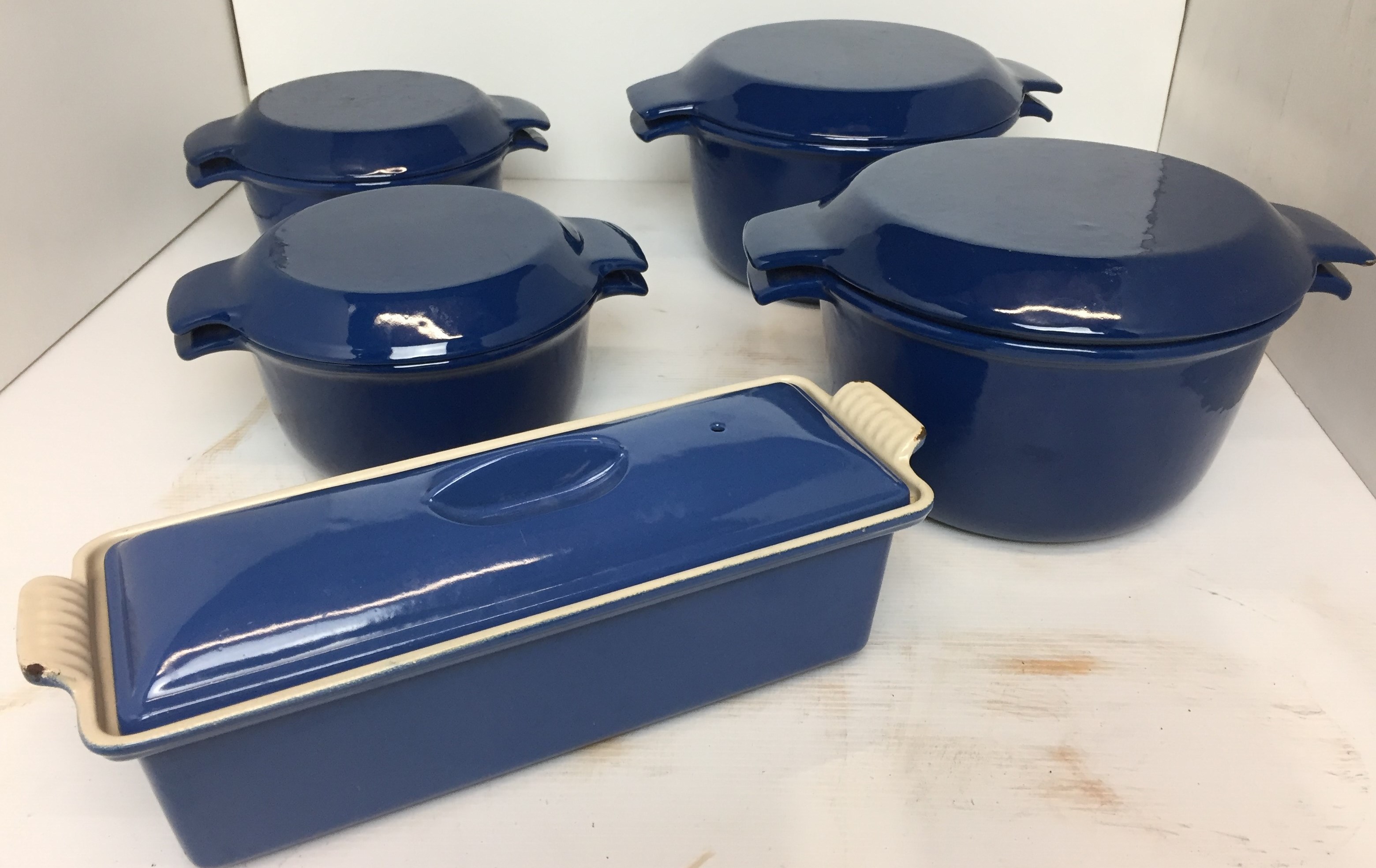 Five pieces of blue enamel cast iron oven to table ware including four casseroles by Nacco of