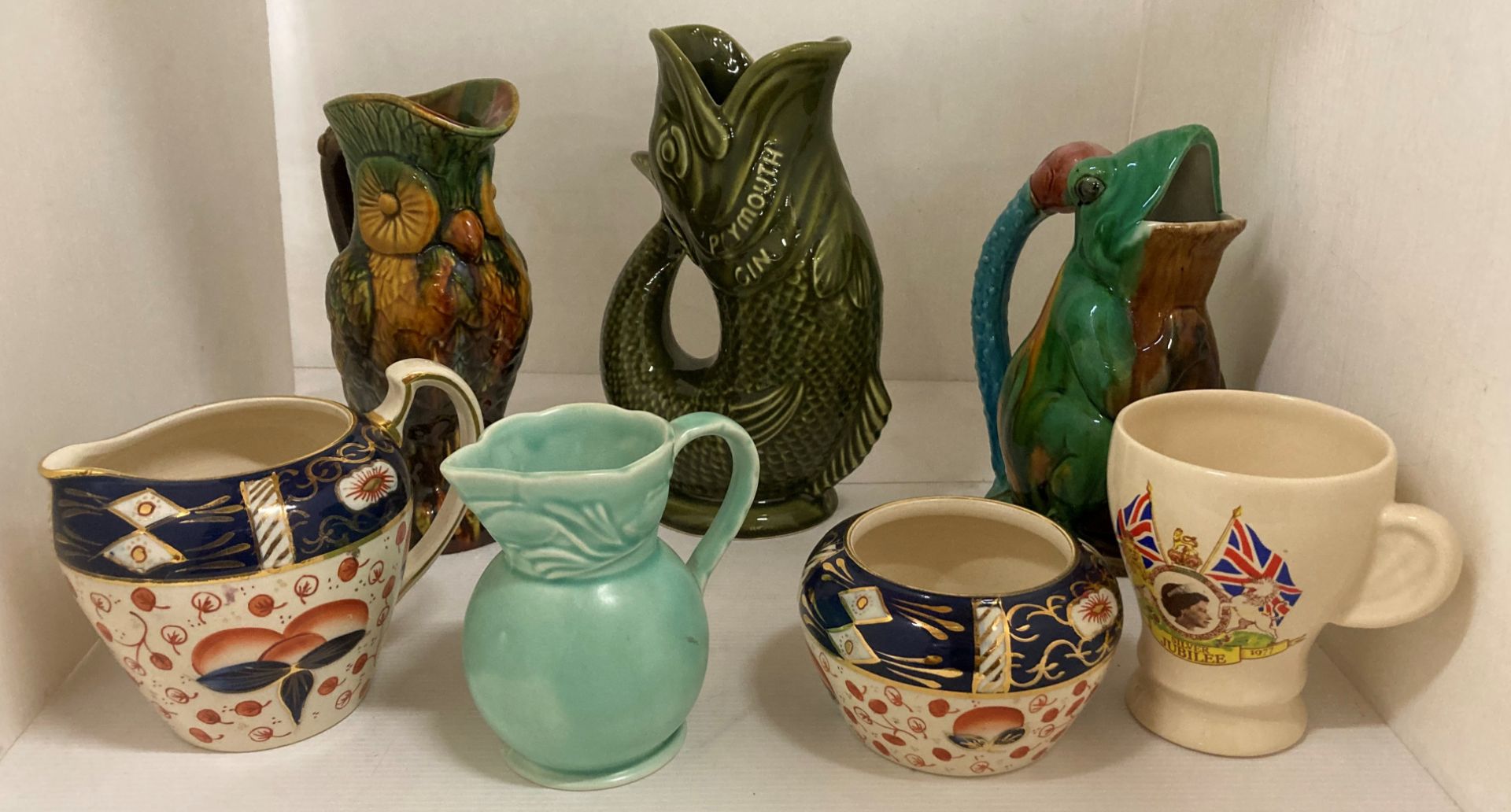 A Dartmouth Devon Plymouth Gin green glazed fish jug, frog and parrot jugs, etc.