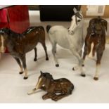 A Beswick grey matt horse looking left, a Beswick brown horse looking right,