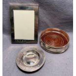 Three sterling silver items - shallow dish 10cm dia, dish with wooden base 12cm dia,