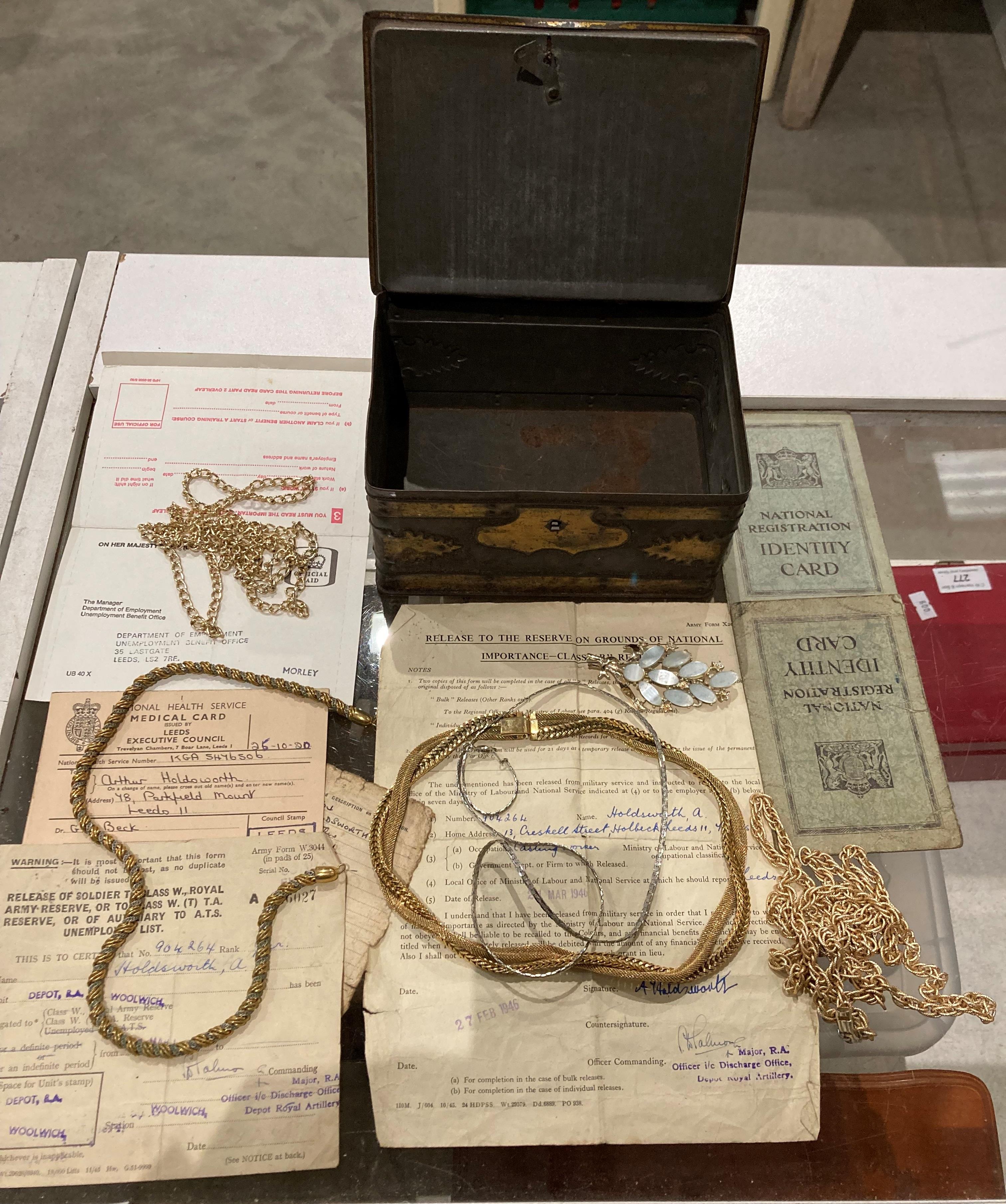 Contents to tin - assorted costume jewellery - necklaces and one brooch and assorted ephemera -