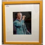 A signed colour photograph of David Bowie in yellow frame (slight scratches to frame) 26cm x 20cm