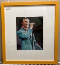 A signed colour photograph of David Bowie in yellow frame (slight scratches to frame) 26cm x 20cm
