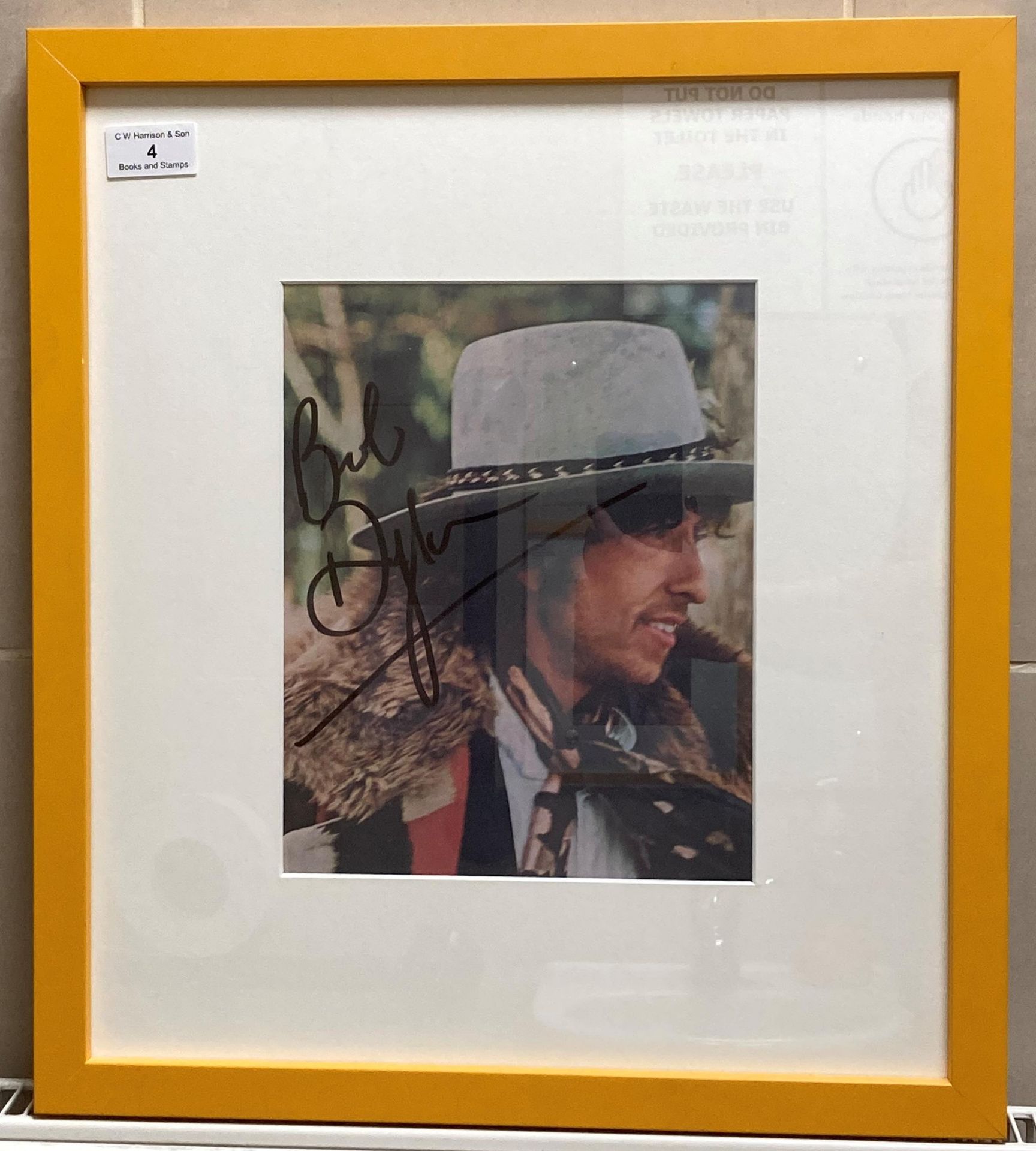 A signed album cover of Bob Dylan 26cm x 20cm in yellow frame complete with a signed note from