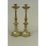 A pair of large brass table lamps of candlestick form with drip pans,