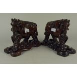 A pair of Chinese carved hardwood elephants on stands