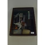 A table top display cabinet containing vintage pens, small boxes, white metal items,