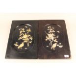 A pair of oriental style lacquered panels with raised decoration,