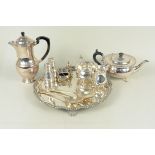 A three piece plated tea set on a plated scalloped edge tray, a pair of plated cat and dog cruets,