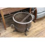 A 19th Century copper log bucket on a wrought iron stand and a copper skillet