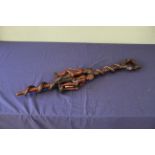 A 20th Century African decorative carved walking stick decorated with human and snake detail