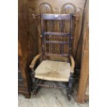 A mid 19th Century carved elm spindle back country rocking chair with later repairs