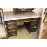An oak early 20th Century nine drawer desk with original brass swan neck handles and leatherette