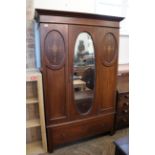 An inlaid Edwardian mahogany wardrobe with mirrored door and drawer