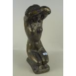 A concrete kneeling female nude with faux bronze verdigris finish,