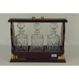 An Edwardian style three bottle tantalus in a mahogany case