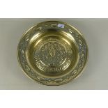 A 19th Century brass alms dish depicting grape carriers within a circle of text dated 1503, 40.