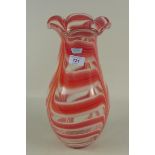 A large glass vase with petal shaped rim and red and opaque glass swirling decoration,
