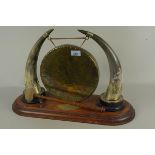 An Edwardian brass and cow horn dinner gong mounted on an oak plinth