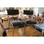 A set of six steel and black leatherette dining chairs