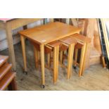 A c.1960's teak table with three drop leaf small tables nestled underneath