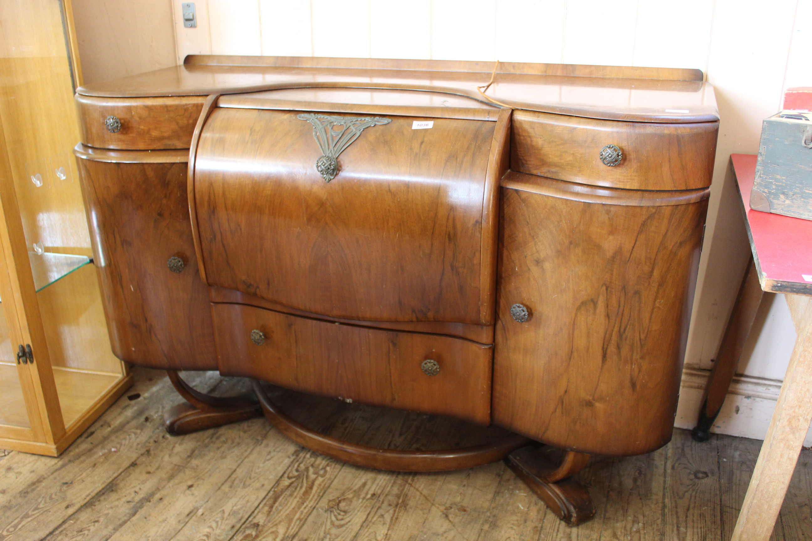 A 1930's style walnut veneered cocktail cabinet with mirrored fall front drinks compartment