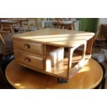 A beech and elm Ercol coffee table on two tiers with two fitted drawers