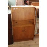 A Remploy teak cupboard bureau with drawer to centre