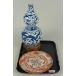 A Chinese porcelain blue and white double gourd vase on stand decorated with dragons,