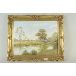 A framed oil on canvas of a river scene with swans and cows grazing,