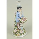 A late 19th Century Sitzendorf porcelain candlestick modelled as a gentleman with a basket of roses,