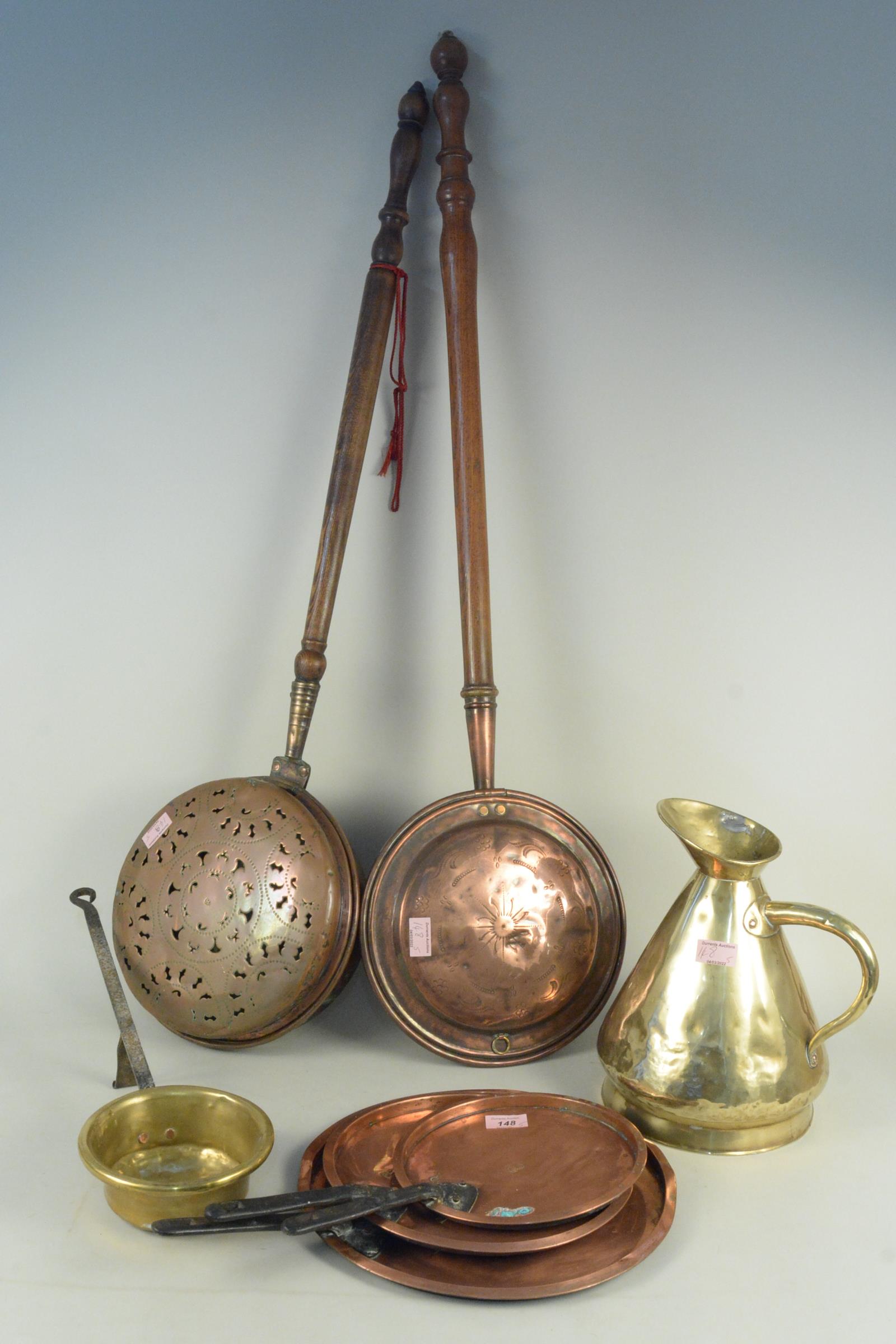 A set of three graduated copper saucepan lids stamped VR, a 1 gallon brass harvest measure,