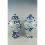A large pair of Chinese blue and white porcelain temple jars and covers with relief carved dragons