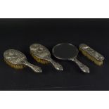 A Chinese silver dressing table set with embossed floral design
