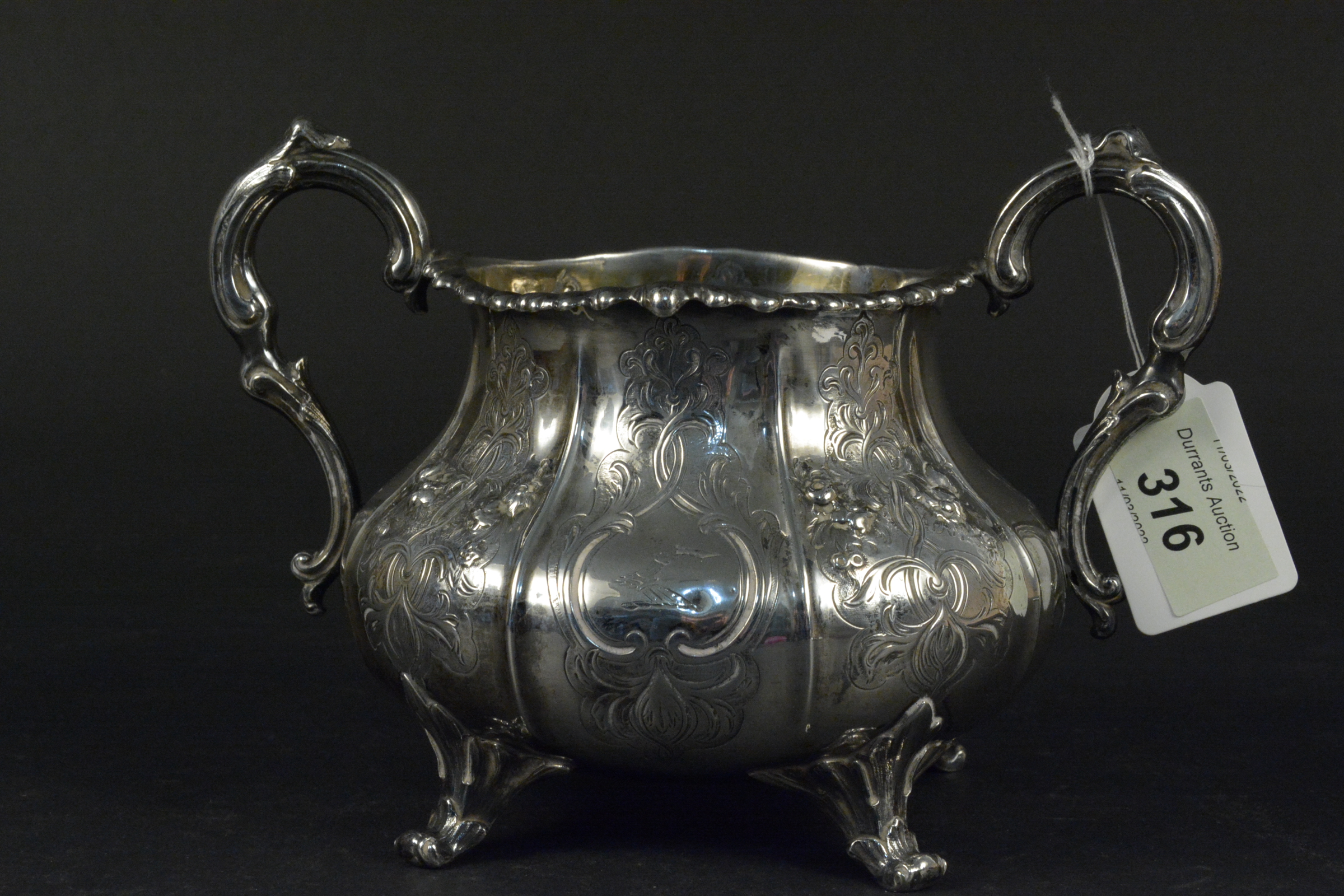 A large silver Victorian two handled sugar bowl with embossed and engraved flora and swag