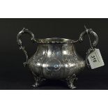 A large silver Victorian two handled sugar bowl with embossed and engraved flora and swag