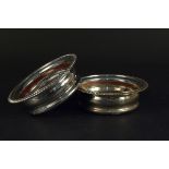 Two silver bottle coasters with turned wood bases,