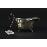 A silver sauce boat with wavy rim on three hoofed feet, hallmarked Birmingham 1941,