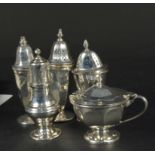 A three piece silver cruet set plus two other silver pepperettes,