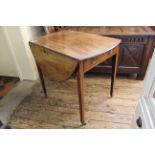 An early 19th Century mahogany inlaid oval Pembroke table with square tapered legs on castors,