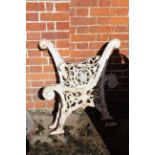 A pair of cast iron garden bench ends with pierced foliate decoration and scrolling arms