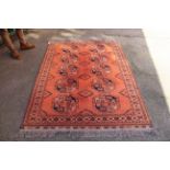 A cinnamon ground Afghan elephant pattern wool rug,