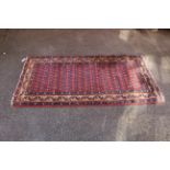 A red and blue ground rug with gold border design,