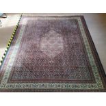 A large machine made wool carpet in the Persian style,