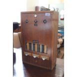 A mid 20th Century teak cased cigarette machine