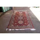 A red ground rug with central medallion design, marked Azerbaijan,