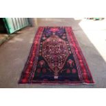 A large black and red ground wool rug,