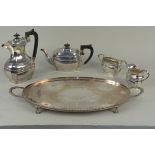 A silver plated four piece tea set on an oval plated tray on ball and claw feet