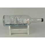 A large size ship in a bottle 'The Cutty Sark' on wooden stand,