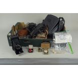 A box of assorted vintage cameras and accessories including Kodak, Praktica 35mm, Olympus,
